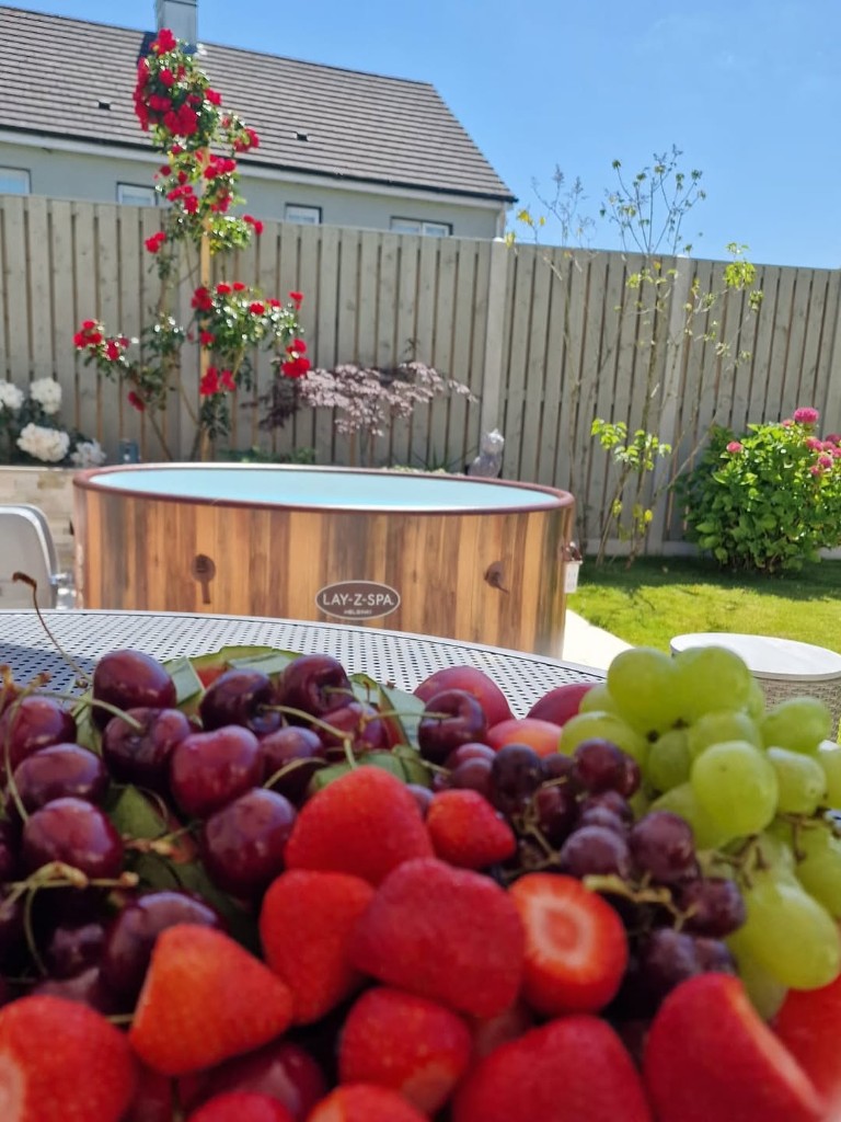 Lay-Z-Spa Helsinki hot tub in a sunny garden with a fresh fruit platter